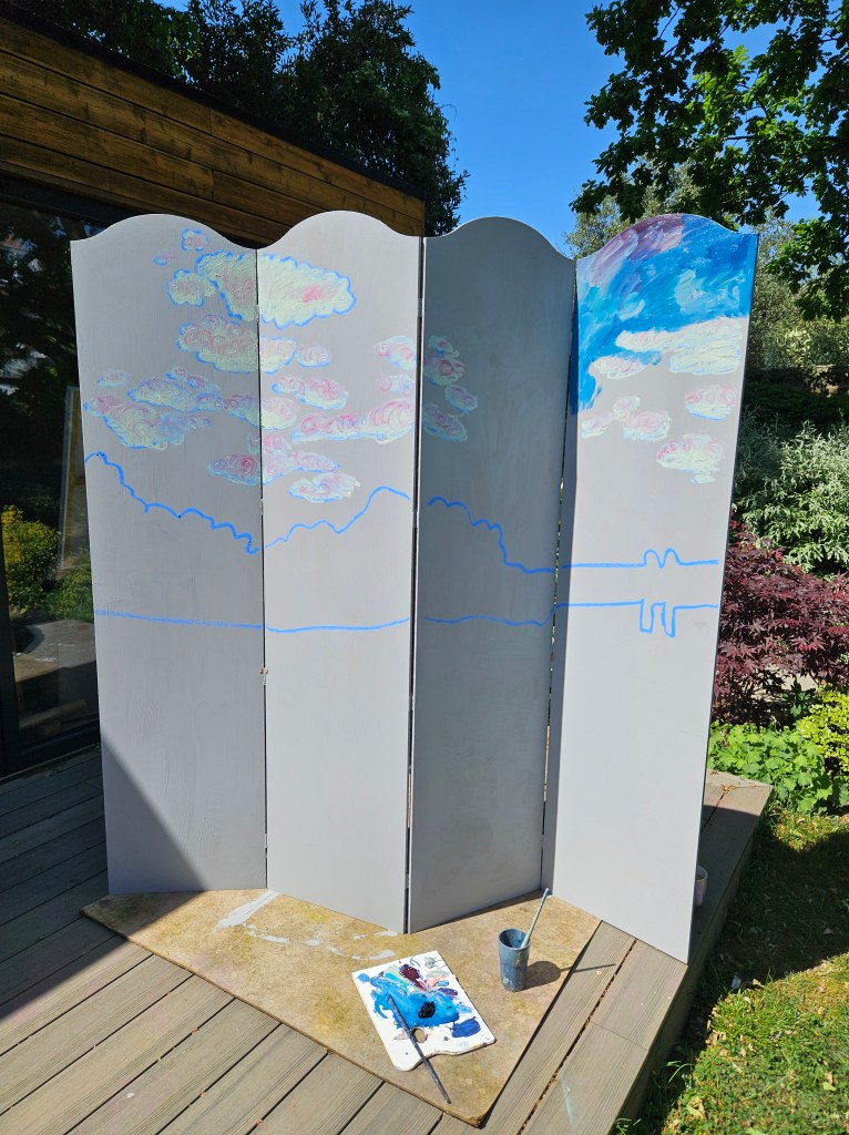 Painted a blue night sky on a wooden folding screen. Photo of the artist painting the screen.